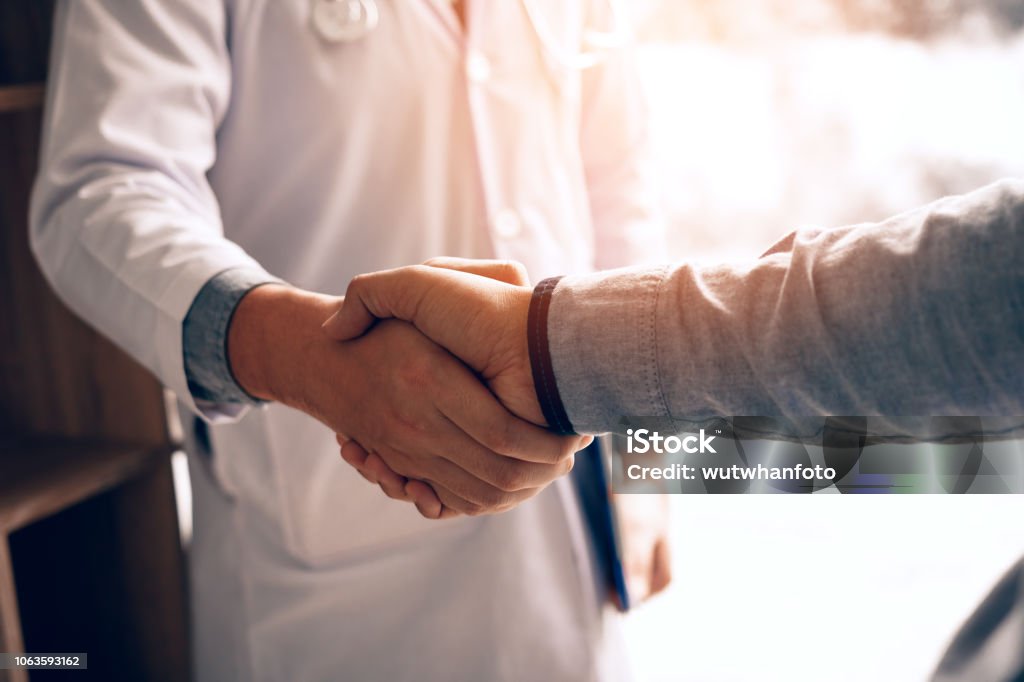 doctor shaking hands with patient in the clinic.